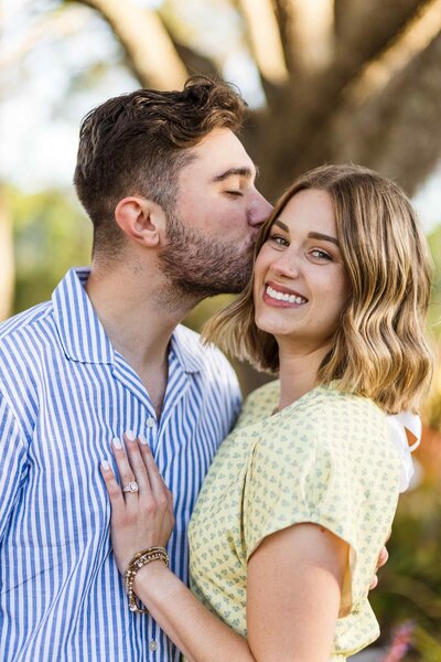 Man kisses his new fianceé's cheek