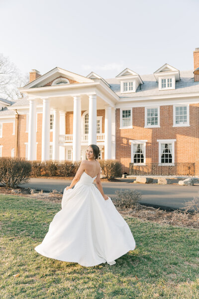 Bride twirling in front of her wedding venue in Leesburg, Virginia at golden hour.