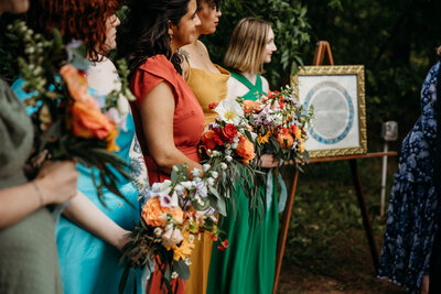 A row of bridesmaids holding bouquet of flowers.