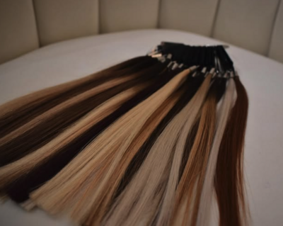 Variety of professional hair extension wefts used for custom extension services at Lavender & Ink Studios
