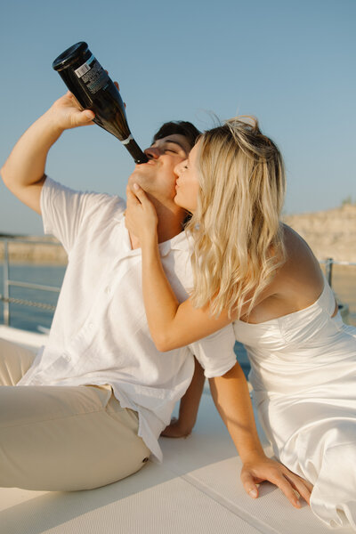 engagement couple on a boat on Lake Travis. Drinking champagne.