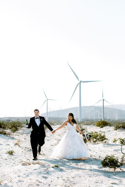 Wedding Photographer, groom kisses bride on side of head, they stand at the beach