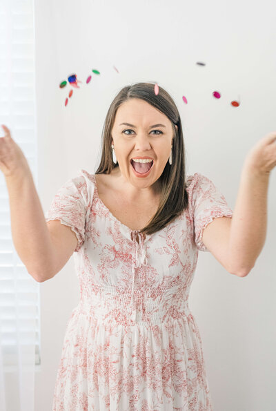 The wedding photographer educator Katiera is smiling and throwing confetti celebrating her wedding photography education business