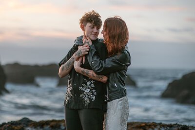 two women embrace during a photo session on the Oregon Coast