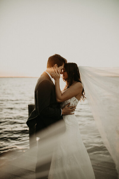 Bride and groom celebrate  their marriage on a dock at sunset at La Venture GRove wedding Venue in fruit cove florida, Moody wedding photography in florida, bridal portraits on dock at sunset in florida, sunset bridal portraits in florida.