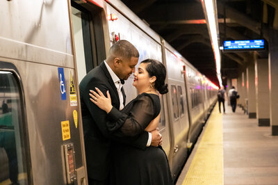 Latino couple embracing at train platform in Grand Central Plaza.