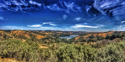 image of  the lamorinda reservoir, with a bright blue sky and water,