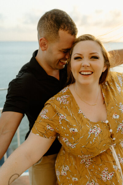 M & E laughing with M standing in front and their hands interlocked like the titantic pose