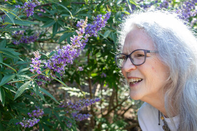 Female author smelling purple flowers