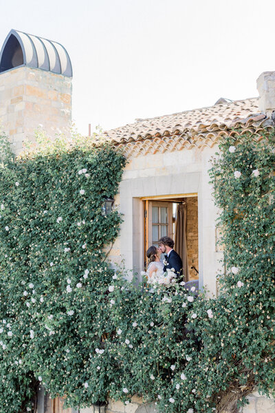 romantic-couple-kissing-balcony-floral-background-wedding-moments