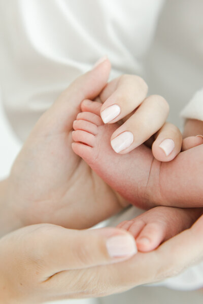 Close up of mom holding her newborn baby's feet during newborn portrait session