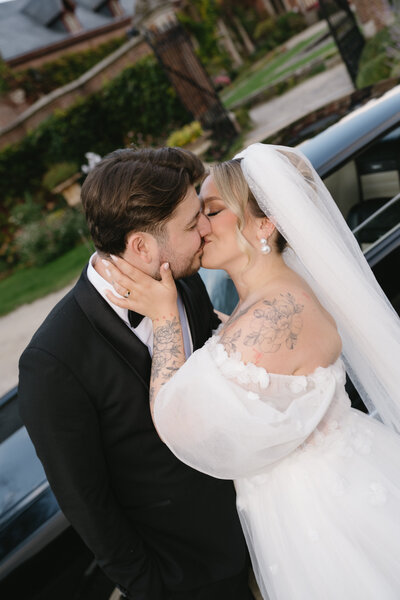 Bruidspaar kust elkaar voor mustang auto.