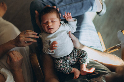 A mom reaching for her newborn baby in a Scottsdale home