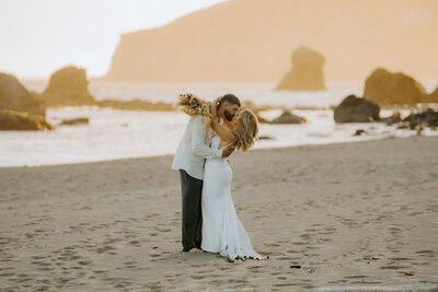 bride and groom kissing on beach