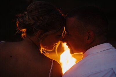 couple sitting by the fire on wedding day