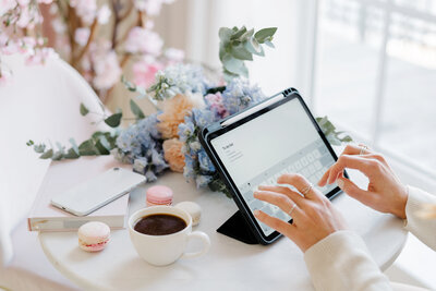 wedding flowers, coffee, and woman typing on tablet