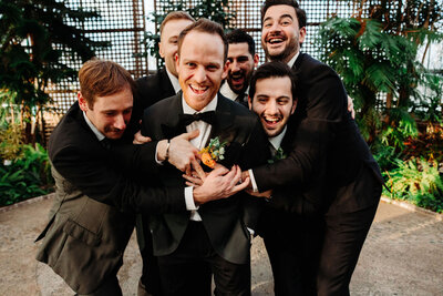 Group of groomsmen hugging groom