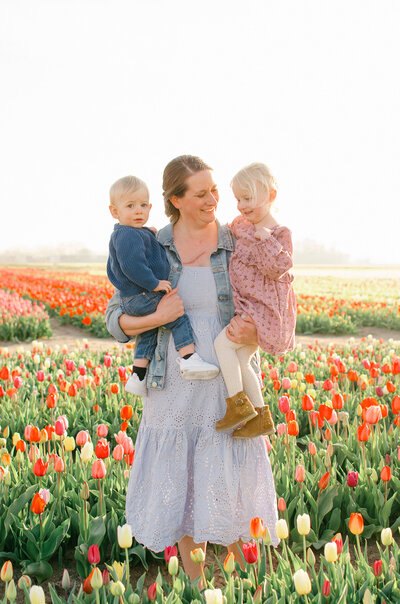 Mother holds her children in the tulip fields near Amsterdam.