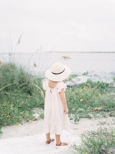 little girl staring out at ocean from photography for moms