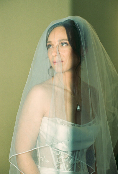 Family of five in front of window father holding infant and two toddlers playing