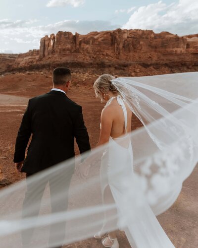 bride and groom standing outside tent