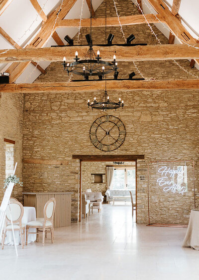 Spacious barn reception space at Caswell House with warm Cotswold stone walls