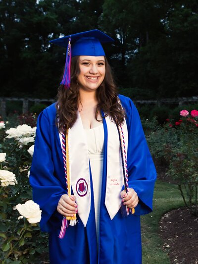 Raleigh High School Senior posing in Rose Garden with her cap & gown.