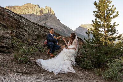 Montana Elopement Photographer poses in the mountains in a yellow coat.