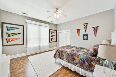 Comfortable bedroom with hardwood floors in historic vacation rental home in downtown Waco, TX