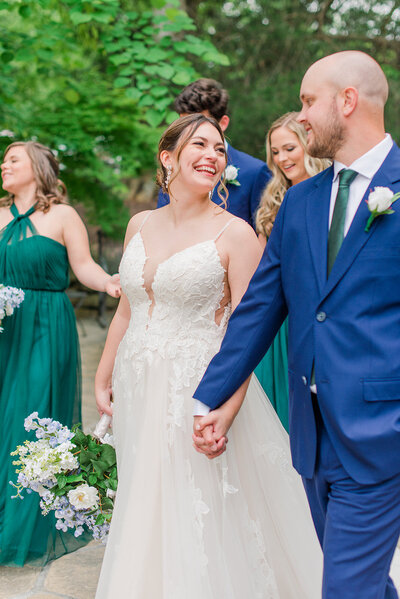 bride and groom smiling at each other while holding hands