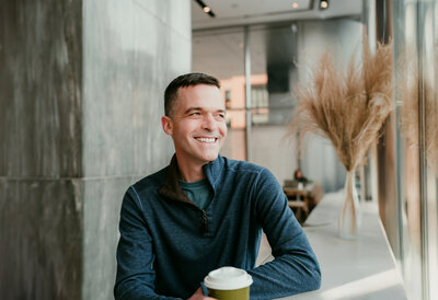 Smiling man with coffee during dating portrait session in Minneapolis, symbolizing confidence and connection. Featured in Shannon Kathleen Photography’s partnership with Three Day Rule matchmaking.