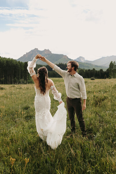 A couple kiss underneath golden aspen trees at a fall elopement in Ouray.