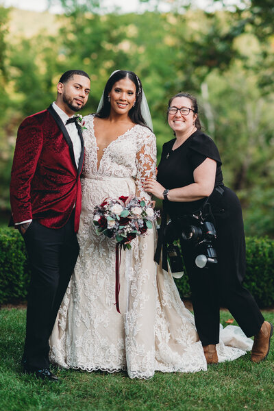 wedding photographer posed smiling with wedding couple