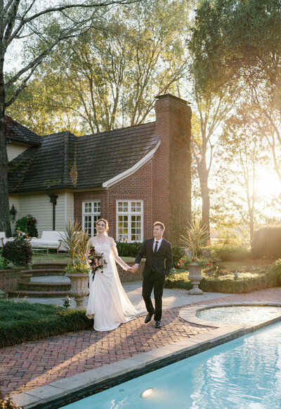 Happily married couple at their wedding reception with bride sitting atop a piano next to her husband by the fireplace in their wedding photos in North Carolina | Megan Smith Photography
