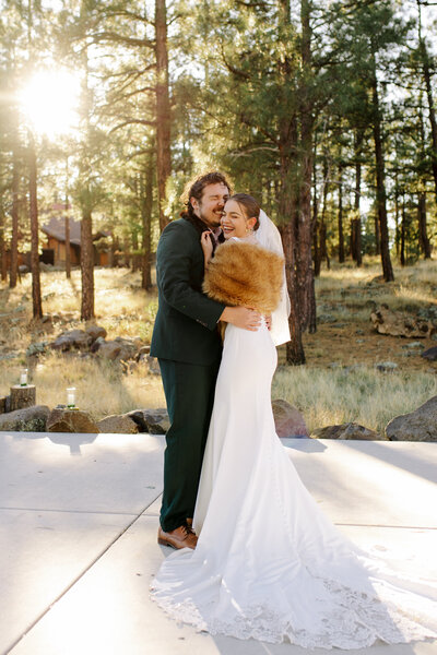 Couple hugging and laughing in cold weather in flagstaff wedding