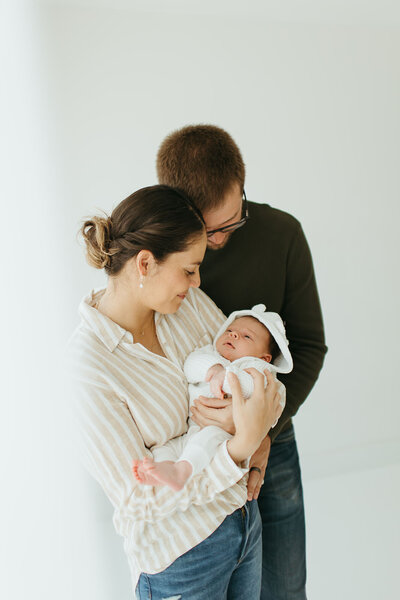 Couple poses with their newborn in a studio with ashley cole photography