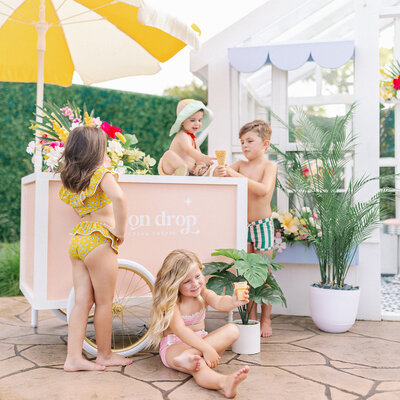 Little kids in swimsuits getting ice cream at an ice cream cart
