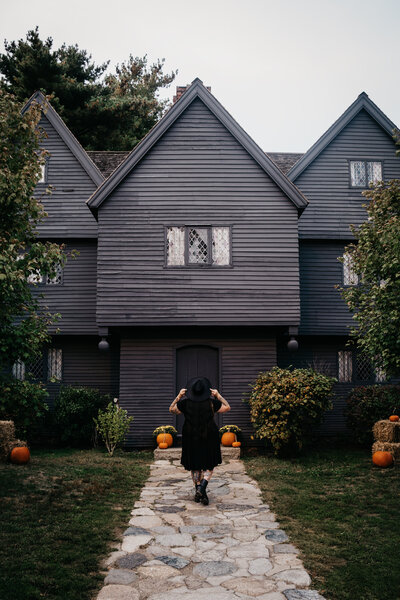 A black and white image of Capitol Region wedding photographer Sarah Anderson standing in the snow looking over her shoulder in a black sweater