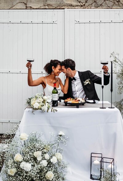Newlyweds clinking glasses during an intimate wedding reception in the Pacific Northwest.
