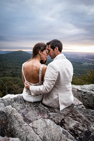 bride and groom embracing on a mountaintop