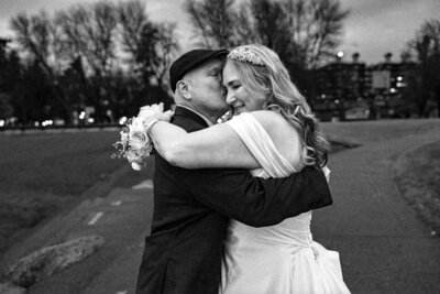 Older couple man in hat bride holding flowers over grooms shoulder smiling.