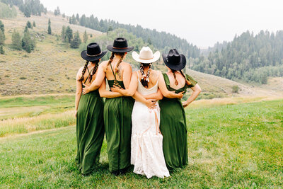 Bride with bridesmaids in cowgirl hats at Wilderness Edge in Cameron, MT