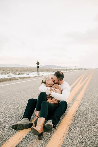 a couple in grand teton national park near the snake river overlook standing next to each other on the road taken by adrian wayment photo