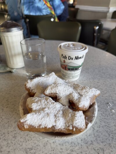 Powdered sugar beignets and coffee at the iconic Cafe du Monde in New Orleans