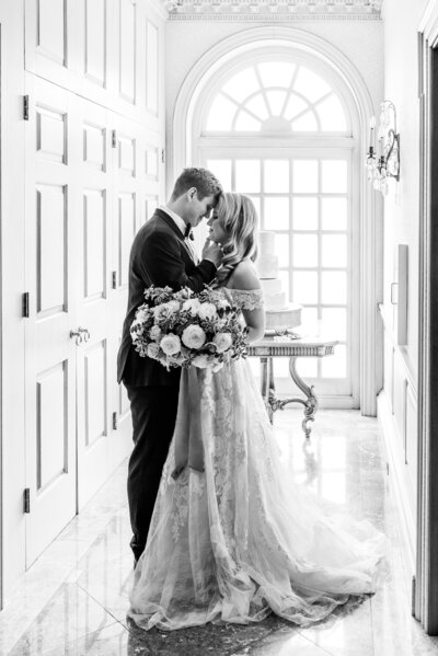 Black and white portrait of bride and groom touching foreheads