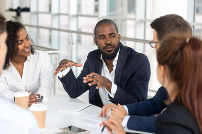 Diverse team engaged in a strategic discussion around a meeting table.