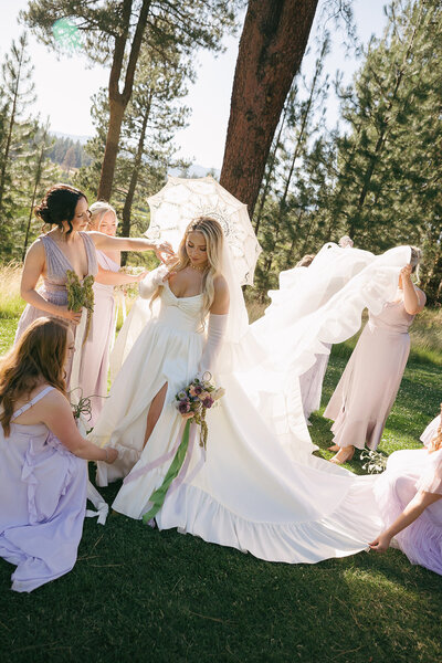 Bride and groom sitting at their head table, sharing a laugh, surrounded by tall floral arrangements.