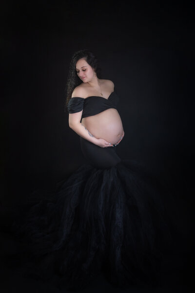 Maternity portrait black on black with bare belly