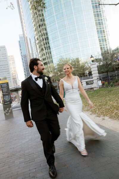 A couple in a tender embrace, the bride's off-the-shoulder white gown and the groom’s attire creating a romantic moment. 