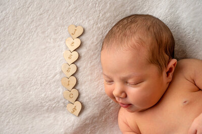 newborn-baby-posed-on-brown-beanbag-for-photoshoot